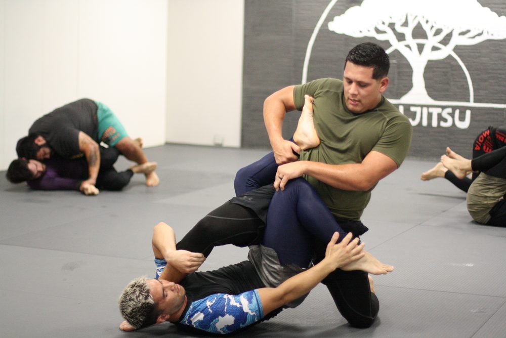 A coach controlling a partner's leg during live training