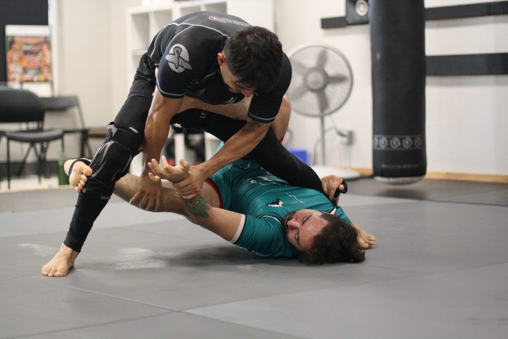 Partners drilling a guard pass during class